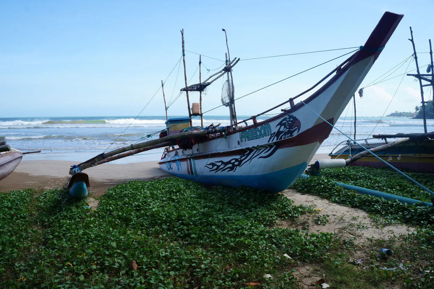 Traditional outrigger fishing boat on Weligama beach in Sri Lanka